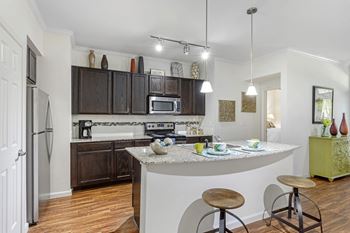 an open kitchen with a bar and stools and a refrigerator